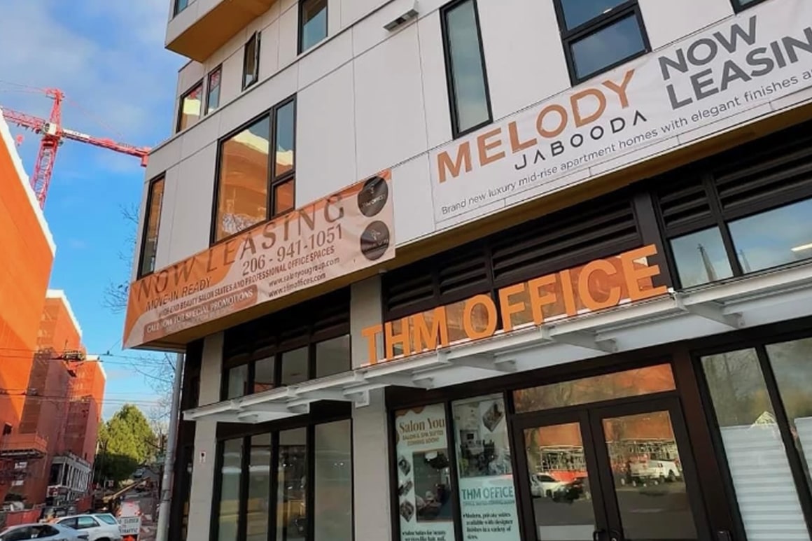 The exterior facade of a mixed-use building, highlighting the entrance and signage for **THM Offices**, managed in partnership with DSM Sophia.